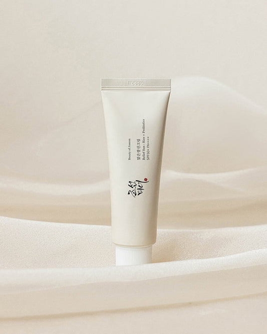 Tube of skincare product on a soft beige fabric background